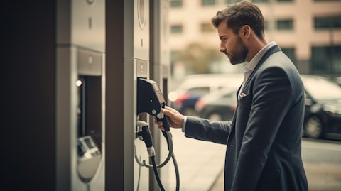 A businessman plugging in to a public charging station, symbolizing the services provided by the company.