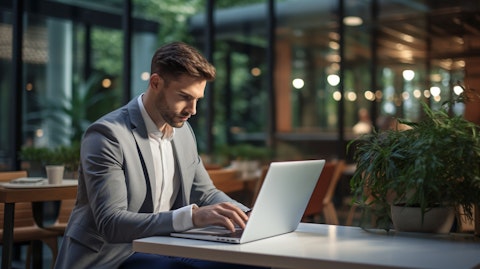 A businessperson checking their balance on a laptop from a modern office space.