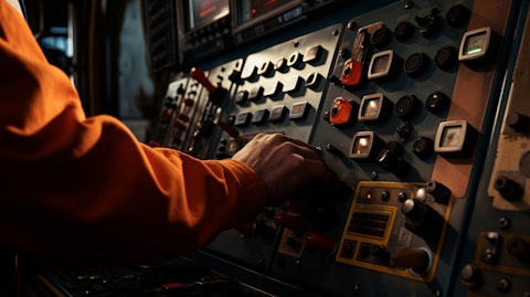 Closeup of a hand maneuvering the controls of an oil rig.