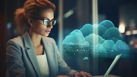 A close-up of a businesswoman using a laptop, being illuminated by the AI-enabled cloud interface sponsored by the company.