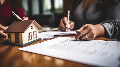 A woman signing papers with her banker for her first home mortgage.