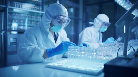 A shot of a laboratory team in lab coats and safety gloves preparing biopharmaceuticals.