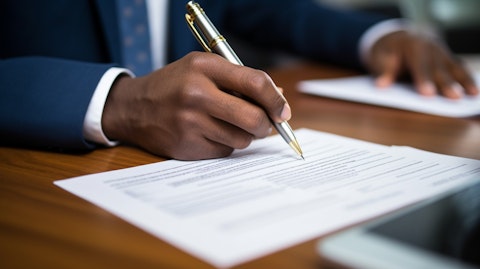 A close-up of a customer signing a mortgage loan document at their local bank branch.