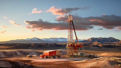 A large oil and natural gas drilling rig in operation, surrounded by a sprawling desert landscape.