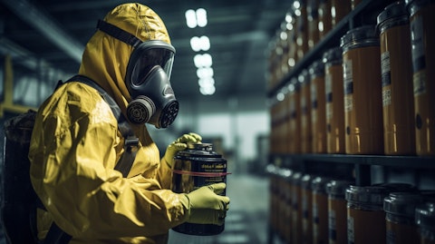 A technician in a hazmat suit holding a refigerant canister inspecting the facility.