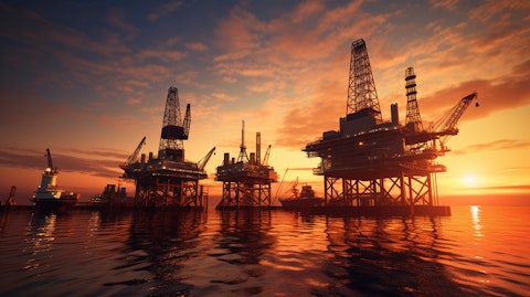 An oil rig in the midst of extracting oil and natural gas from the earth, illuminated by the setting sun.