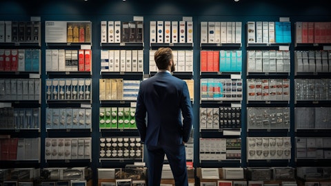 A businessman in a suit looking at a wall of promotional products in a store.