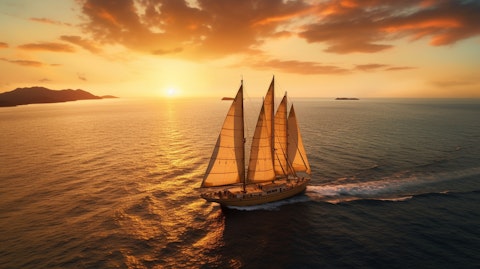 A large yacht sailing in the open sea with passengers enjoying the sunset.