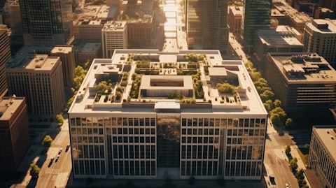 An aerial shot of a commercial city center revealing a large office building with the company logo.