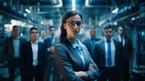 A female executive surrounded by a team of employees in a manufacturing factory manipulating advanced materials and chemicals.