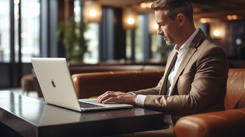 A business person typing on a laptop in a hotel lobby emphasizing the comfort and sophistication of the company's travel offerings.