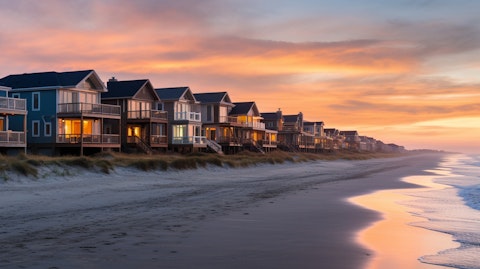 A row of beachfront vacation homes owned by Vacasa, in the backdrop of a picturesque sunset.