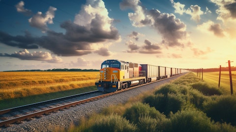 A freight train rolling through the countryside carrying a full load of products.