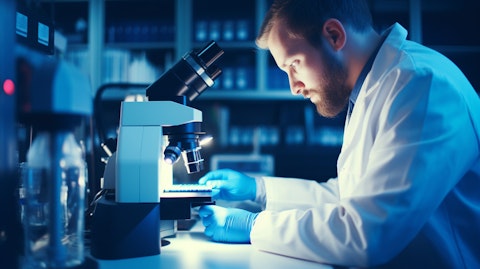 A researcher examining a microscope in a laboratory to further their clinical-stage discovery.