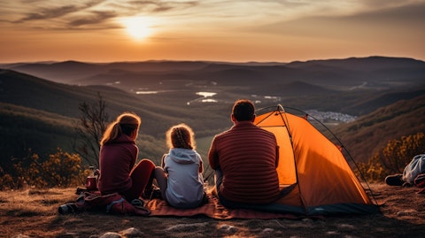 A family of four on a camping trip, their tent pitched under a scenic mountain view.