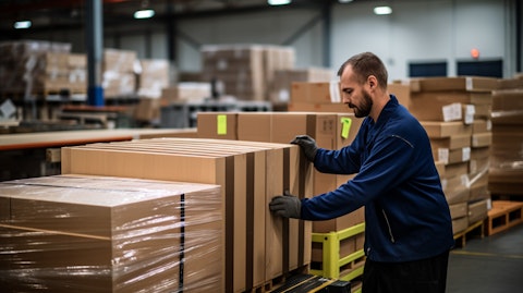 A worker in a warehouse packaging a modern storage furniture.