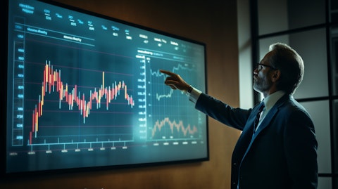 A businessman's hand pointing to a graph on a projector screen illustrating economic trends.