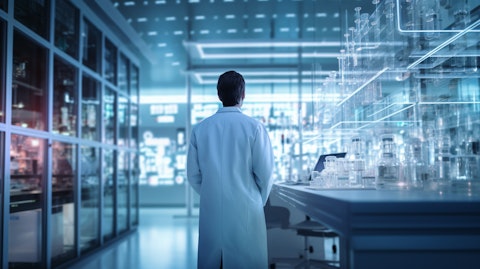 A person in a white lab coat standing in a modern biotechnology research laboratory.