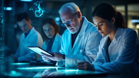 A biomedical research team taking notes and making calculations on tablets after testing preclinical product candidates.