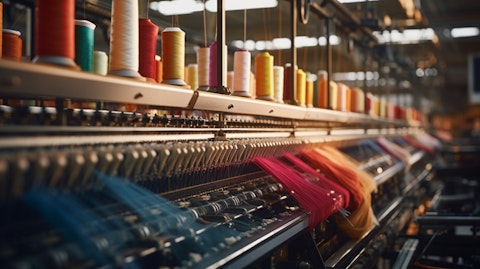 A view of a busy textile factory, machines churning away in the background producing yarns.