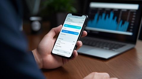 A close up of a person's hand using a mobile banking app.