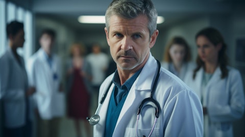 A doctor in focus surrounded by colleagues in a hospital setting.