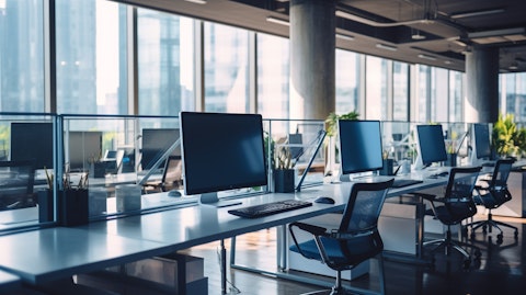 A row of desks in a modern office, filled with a diverse workforce.
