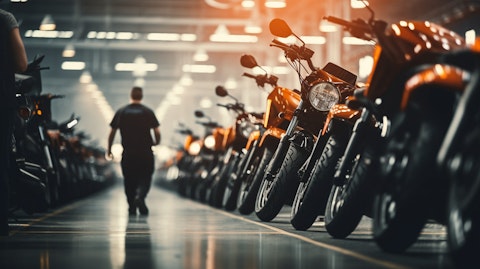 A fleet of motorcycles and vehicles lined up in an assembly line with workers in the background.