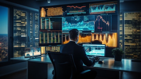 A business professional in a room with multiple screens reviewing analytics of digital inventory.