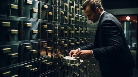 A bank teller counting currency notes in a safe deposit box.