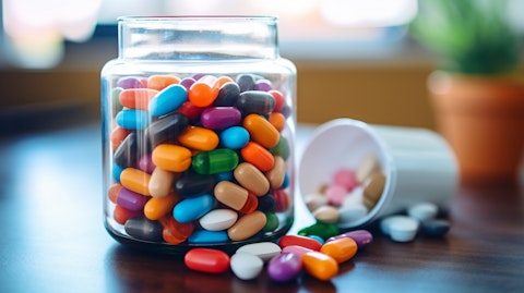 A close up of a glass jar filled with colorful vitamin and mineral supplements.