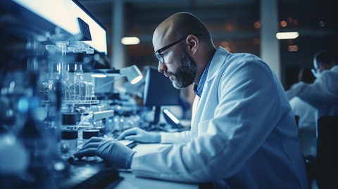 A chemist looking through a microscope in a research and development facility as they synthesize recombinant proteins.