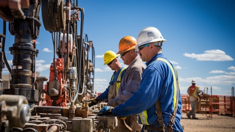Oil and gas workers operating high horsepower pumps on a hydraulic fracturing site.