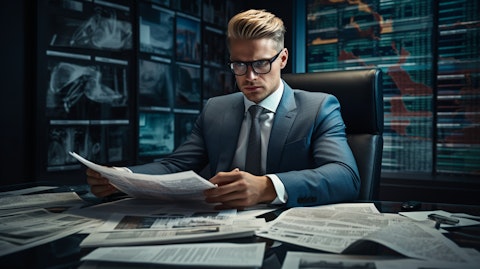 An executive in a stylish suit at a large desk surrounded by financial reports.