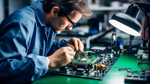 A technician at a workstation, soldering electronic components for vehicle tracking devices.