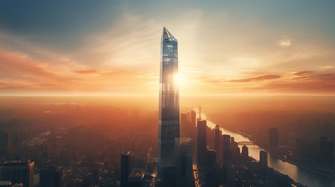 Aerial view of a skyscraper contrasted against the rising sun.