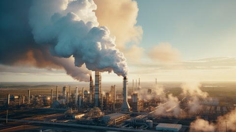An aerial view of an industrial natural gas refinery, with smoke billowing out.