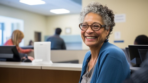 An older Medicare-eligible consumer smiling happily while receiving healthcare services at a clinic.