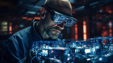 A technician wearing a head-mounted augmented reality headset examining a MEMS device.