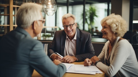 A banker speaking with an elderly couple discussing the benefits of a savings accounts.