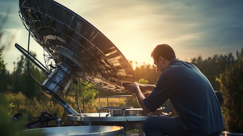 A technician preparing a broadcast satellite dish for transmission of cable content.