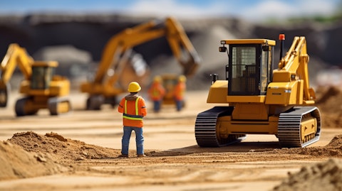 A worker wearing a safety vest supervising a team of bulldozers leveling the ground for a road construction project.