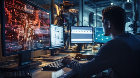A student operating a computer numeric control machining program, surrounded by computer technology.