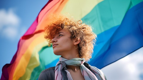 A young queer person looking up at a giant LGBTQ flag, celebrating visibility and inclusion.