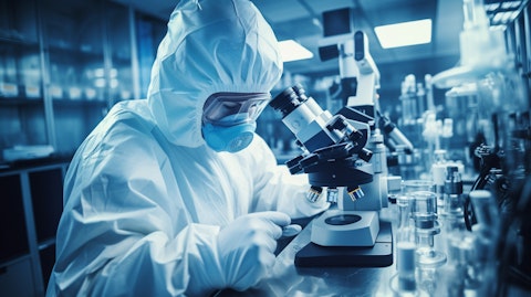 A scientist in a lab wearing a protective gear, working with a microscope on a biopharmaceutical drug.