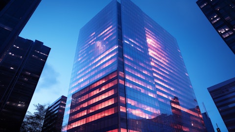 A high-rise office building with exterior illuminated in the company's colors, symbolizing the company's presence in the financial industry.