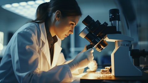 Close-up of a specialist examining a skin sample under a microscope.