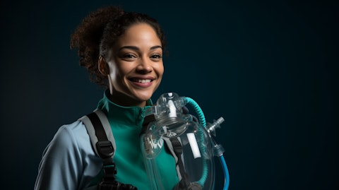 A smiling healthcare worker holding a SmartVest airway clearance system. .