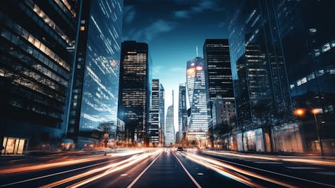 A bustling financial district lit up at night, showcasing the company's regional banking services.