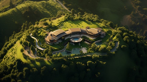 A sweeping aerial view of a hospitality service lodge nestled atop a lush hillside.